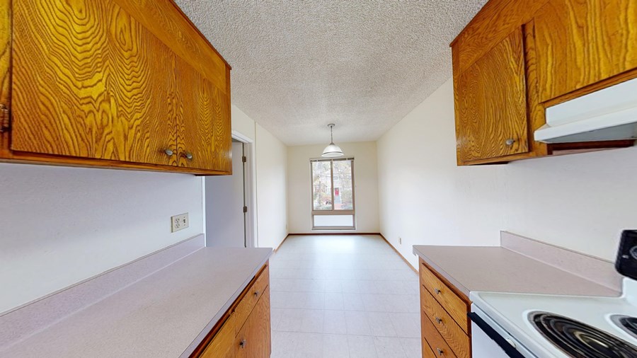 A kitchen with wooden cabinets and a stove top oven.